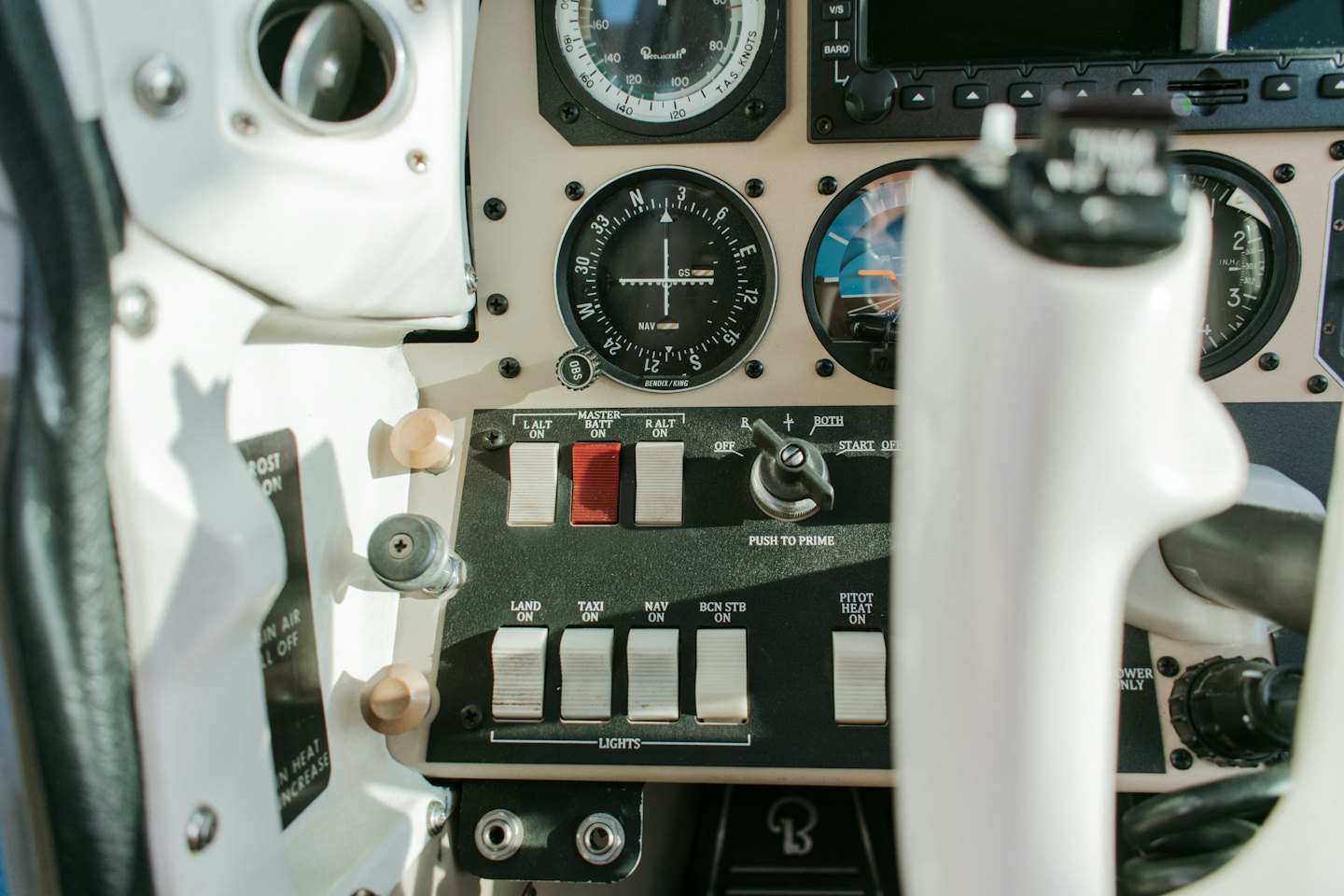 Beige und schwarzes Flugzeugcockpit-Instrumentenbrett mit vielen Bedienelementen.