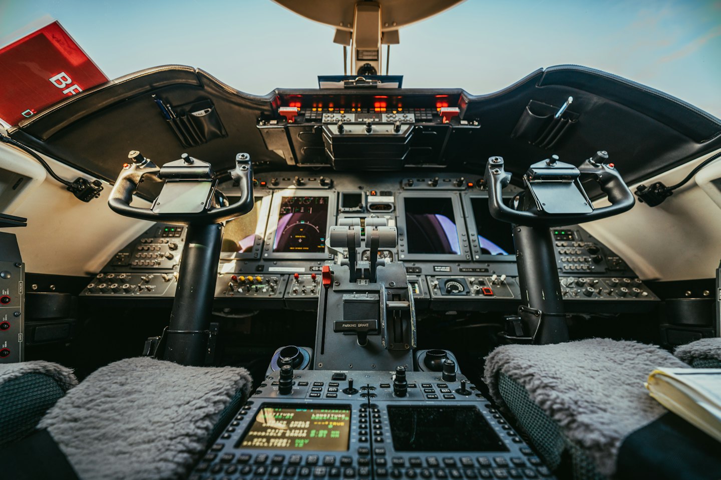 Moderner Flugzeugcockpit mit Steuerhörnern und Flugdisplays.
