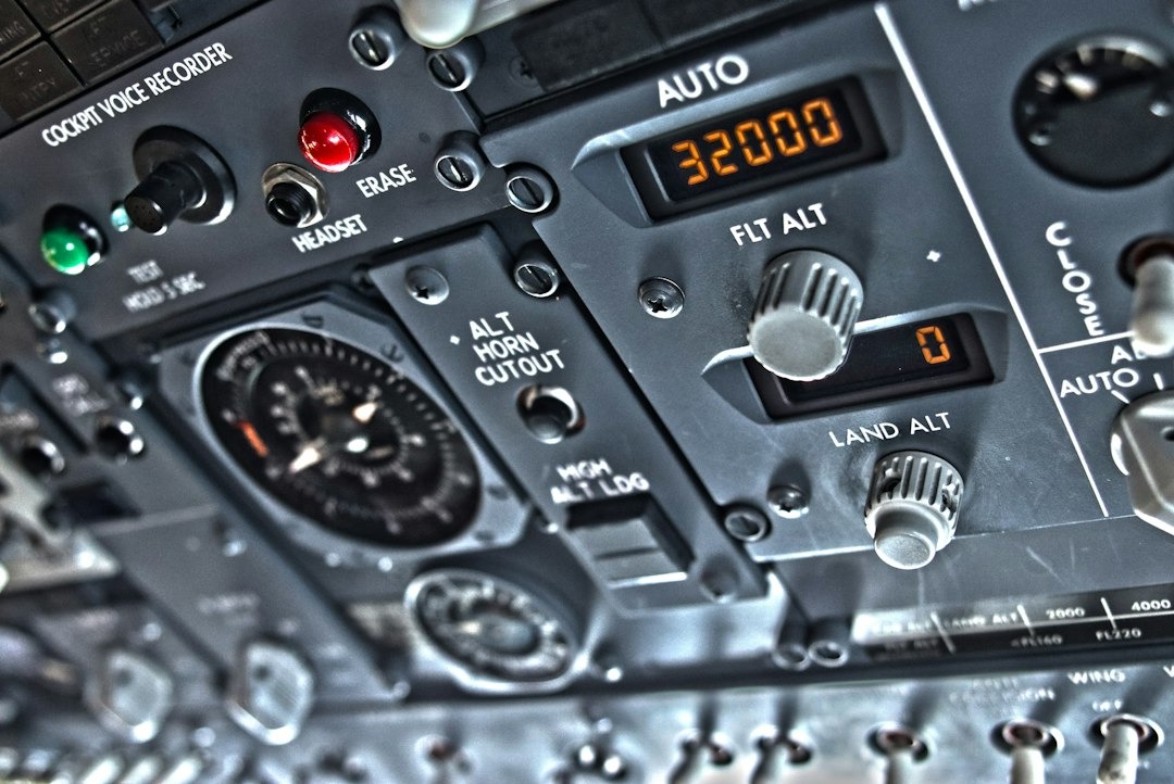 Airplane cockpit overhead control panel with digital displays.